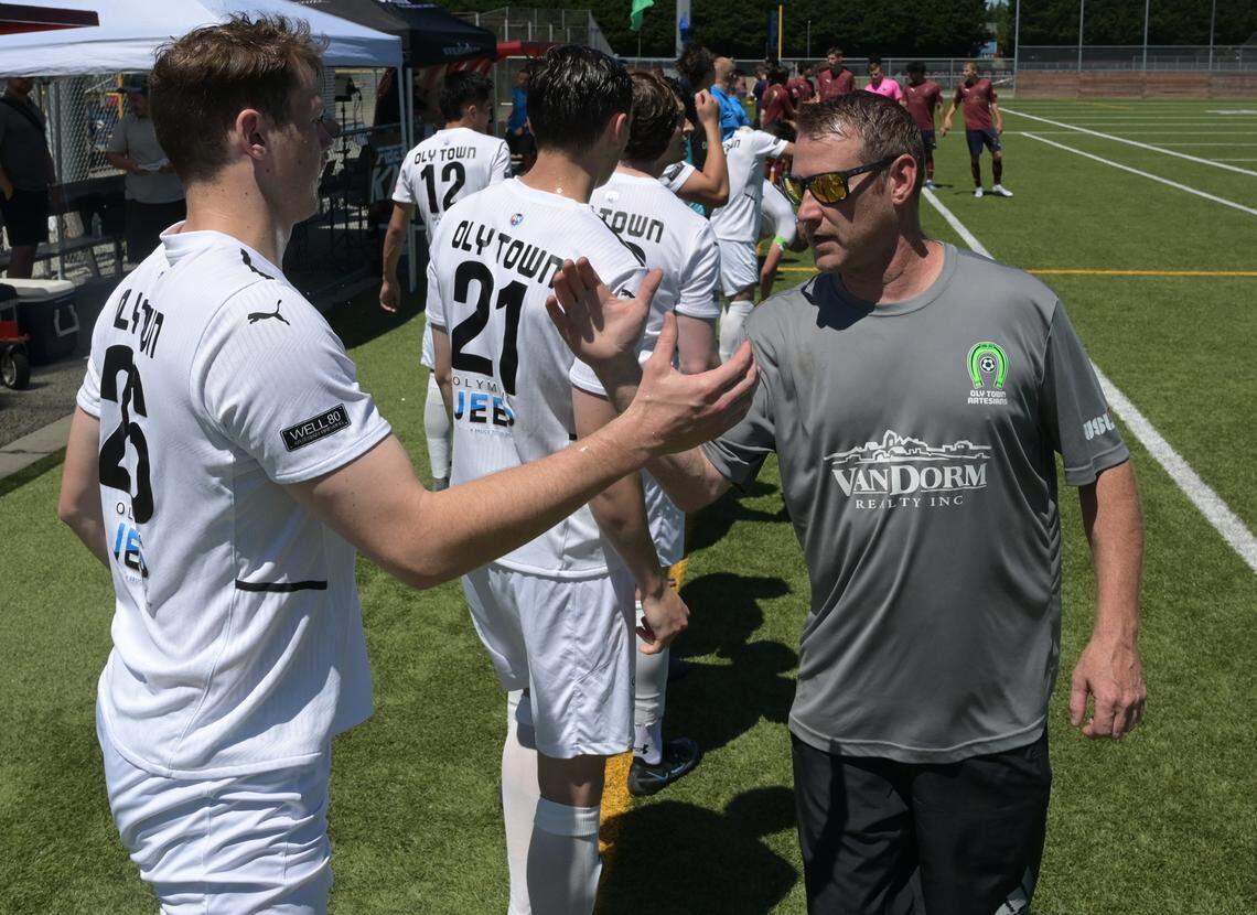 Oly Town Artesian FC head coach Jason Smith shakes hands with Col Dobson before taking the field against visiting Oregon Valley Futbol Alliance from Oregon in a USL League Two match at Black Hills High School on June 26, 2022.