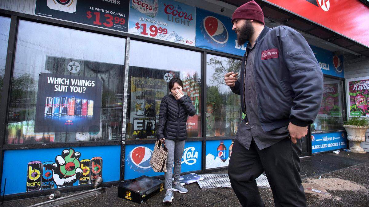 Unique Nails owner Daisy Tran and Jiffy Lube manager Nate Davison coordinate how to get their businesses back open and damage repaired as they meet outside the Texaco Food Mart at Black Lake Boulevard and Cooper Point Road in west Olympia that was destroyed by an early morning fire Friday. The fire knocked out power to the five businesses in the complex.