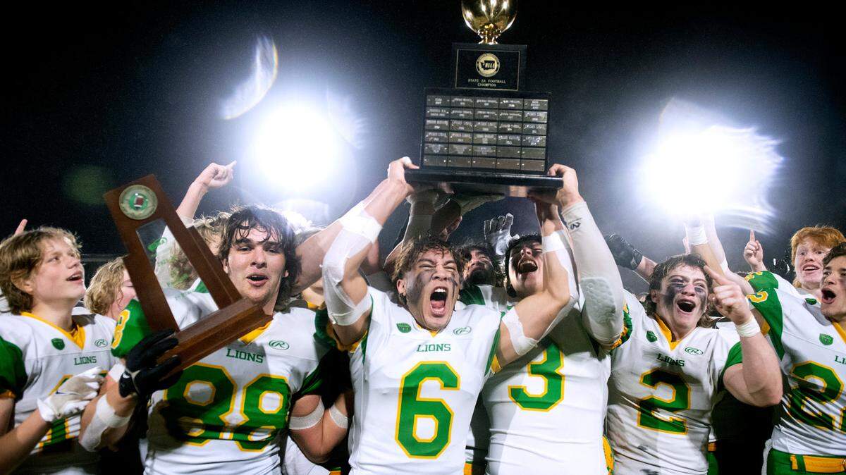 The Lynden Lions celebrate their 2A football state championship win over the Tumwater T-Birds, 21-7, at Sparks Stadium in Puyallup, Washington, on Saturday, Dec. 4.