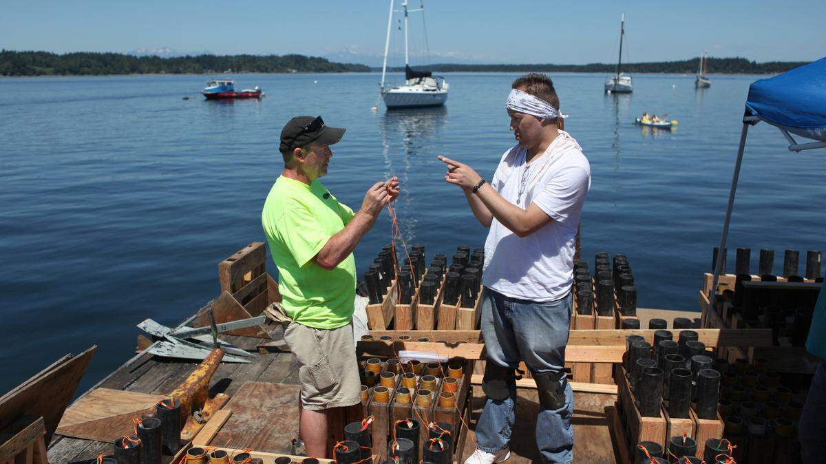 Herb Harris (left) and Joseph Genovese of Wolverine West Fireworks set up the 500 mortar shells on the launch boat for the Boston Harbor fireworks display on Wednesday, July 3, 2013. 