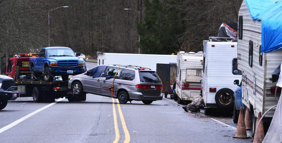 Several towing company trucks shuttled in and out of Ensign Road near Providence St. Peter Hospital Wednesday as part of a project to clear vehicles that have been serving as homes.