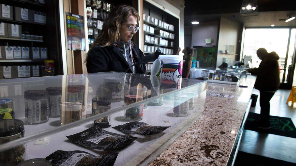 Ryley Bolt of Tacoma works behind the counter at Emerald Leaves recreational cannabis shop in Tacoma, Washington, on Thursday, Jan. 20, 2022.