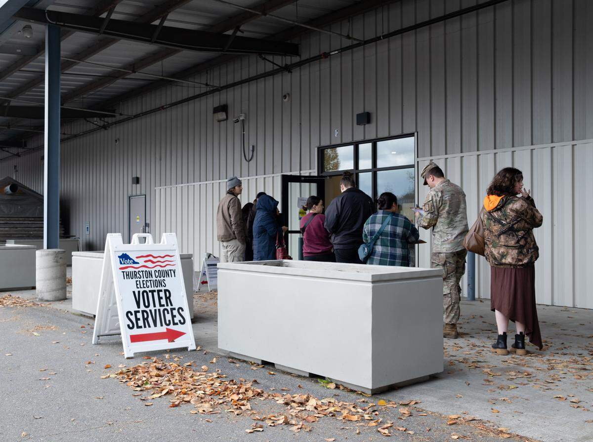 About two dozen voters lined up along the outer wall of Thurston County’s primary voting center in the Tumwater Mottman neighborhood on Tuesday, Nov. 5, 2024.
