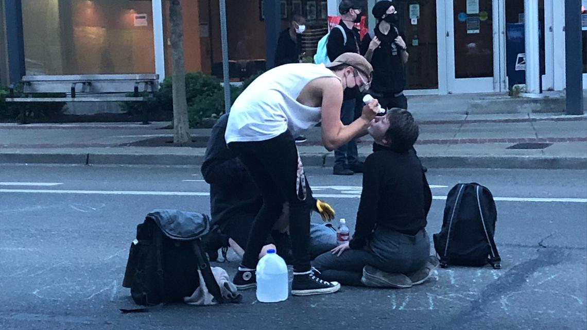 A protester helps a woman who was sprayed with a chemical irritant after a skirmish between her and a third person during a tense, but largely peaceful protest in downtown Olympia last Thursday night.