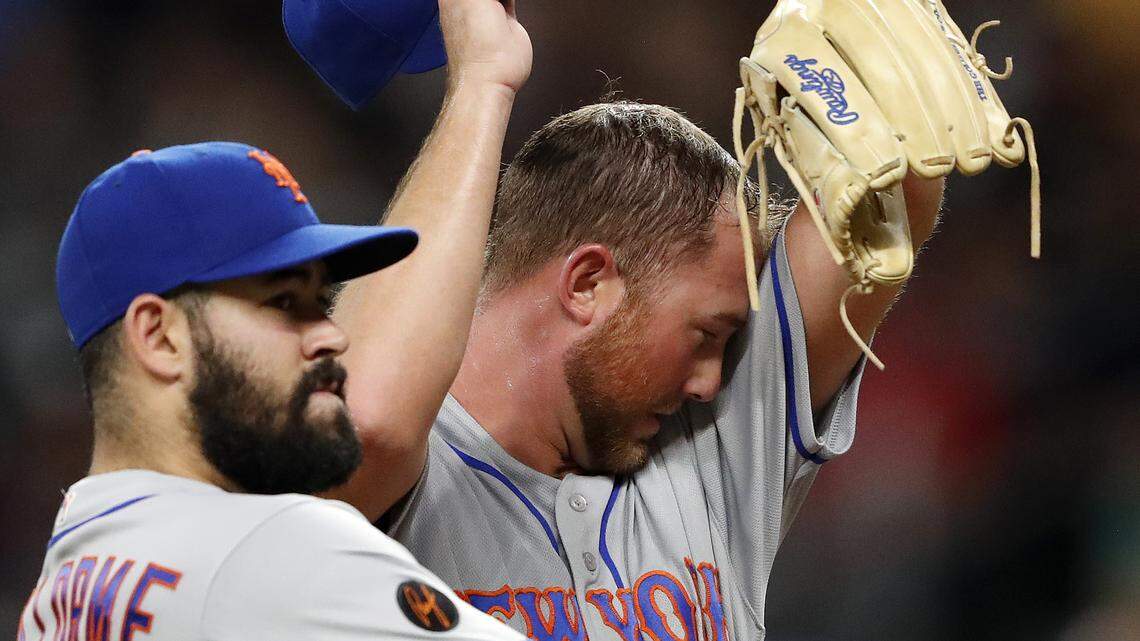 New York Mets relief pitcher Tim Peterson wipes his face as he waits for a visit from the team's pitching coach in the seventh inning of a baseball game against the Atlanta Braves on Wednesday, May 30, 2018, in Atlanta. (AP Photo/John Bazemore)