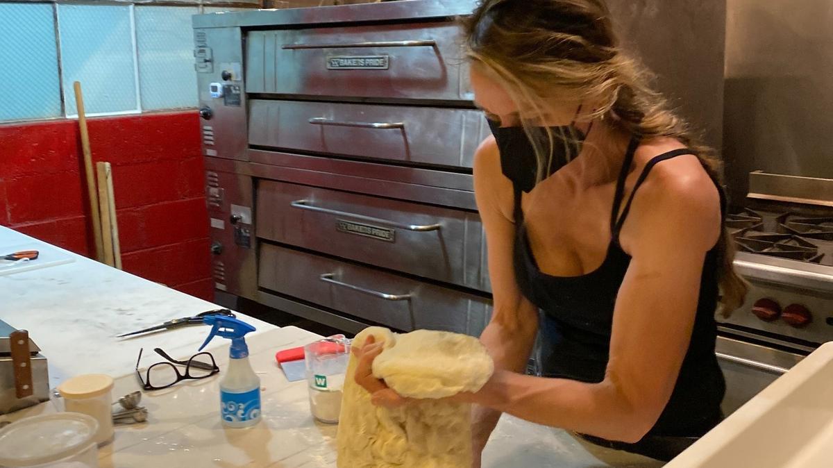 Lisa Scott Owen, owner of The Mark in downtown Olympia, works some pizza dough in the restaurant’s kitchen.