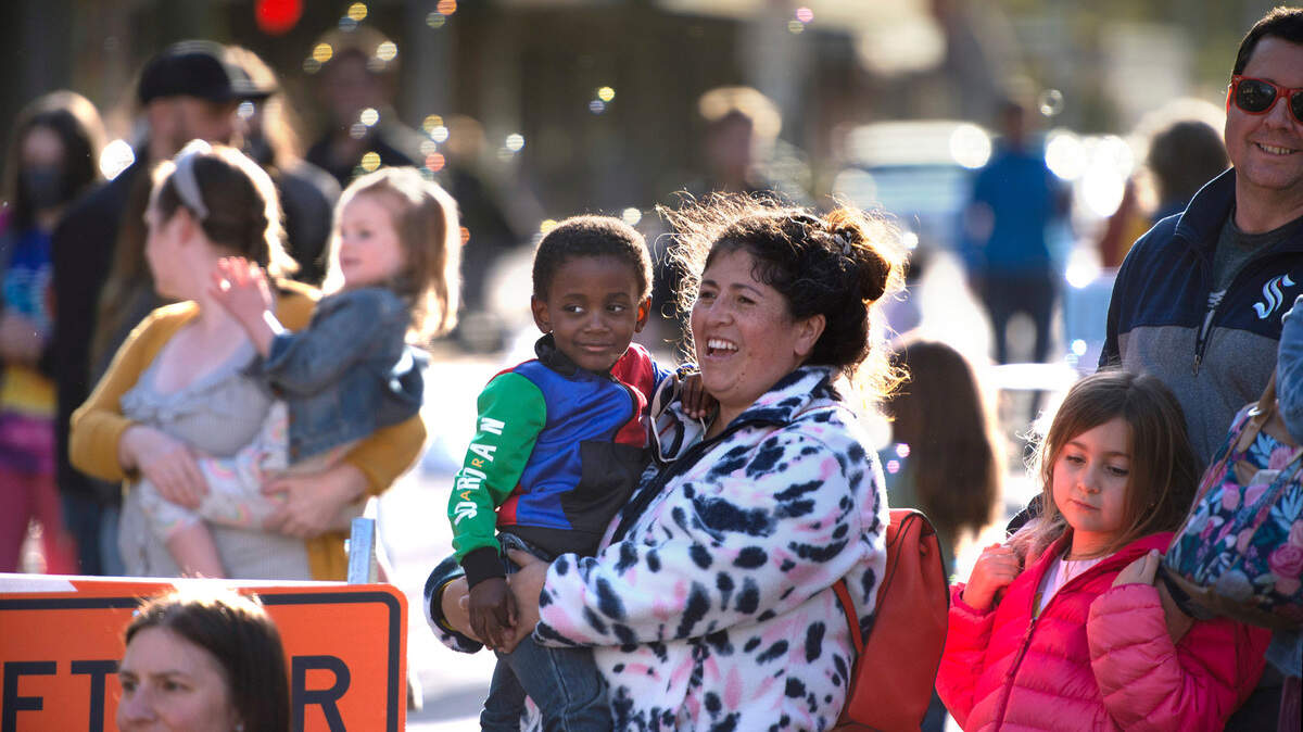 The Hartt Plazas family (from right) dad Jordan, daughter Kataleya, 7, mom Berenice and son Skyler, 3, watch juggler Jules McEvoy, aka Jules the Juggler, of Bellingham perform during Arts Walk 2022 in downtown Olympia, Washington, on Friday, April 22, 2022.