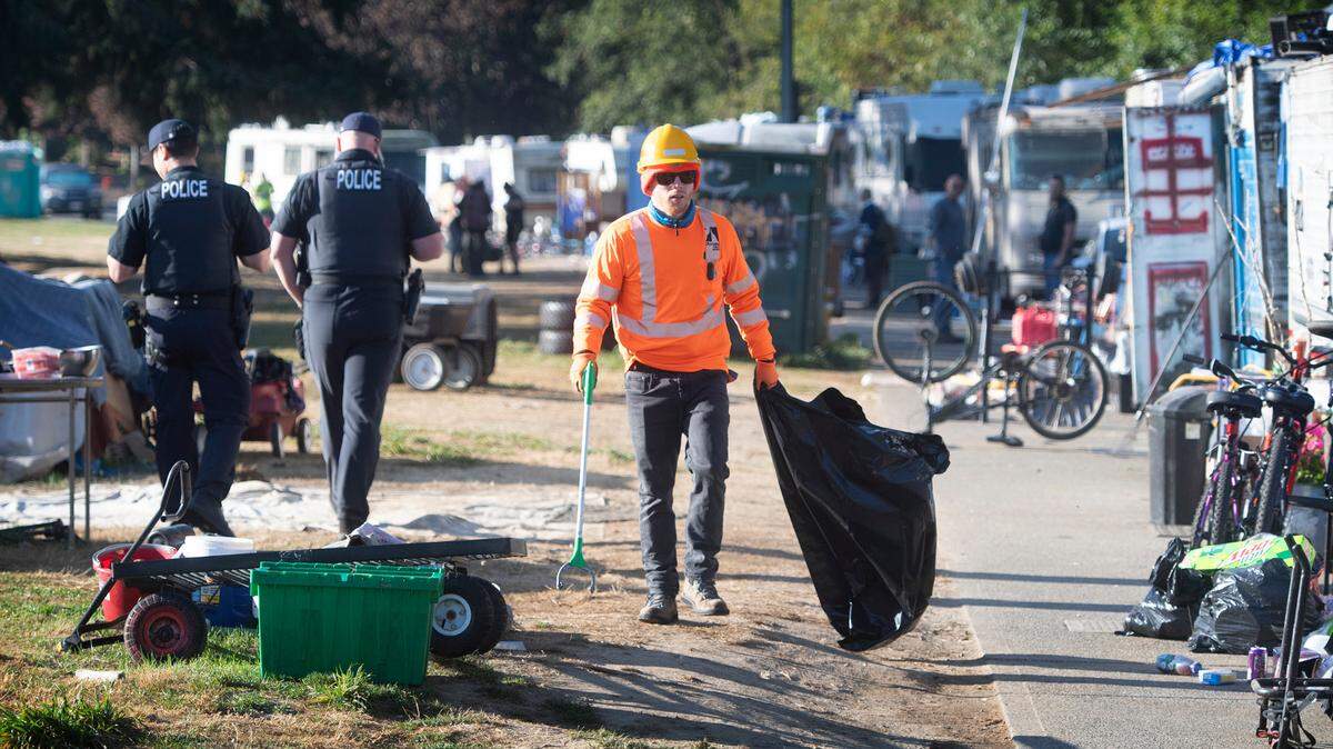 City work crews, police and crisis outreach workers gather to help with the clearing and relocation of residents living in their vehicles at the permitted RV parking area along Ensign Road in Olympia, Washington, on Wednesday, Sept. 21, 2022. The city plans to have the street completely cleared by mid-October.