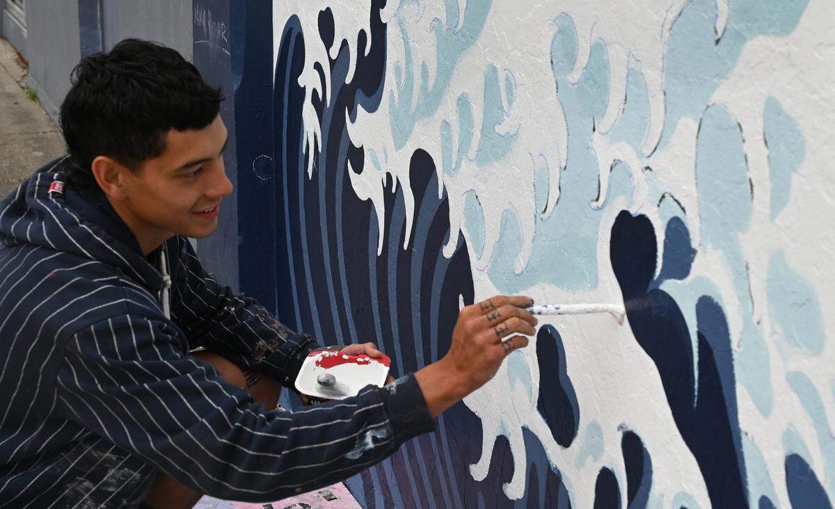 Painstakingly finishing every detail big and small, local artist Austin Davis has worked restoring the landmark “Great Wave” mural that has adorned the west-side wall of the Childhood’s End Gallery in downtown Olympia since 1977. The mural’s creator, well-known regional artist Joe Tougas, has been observing the project and even added his expertise by handling some of the fine handwork detailing.