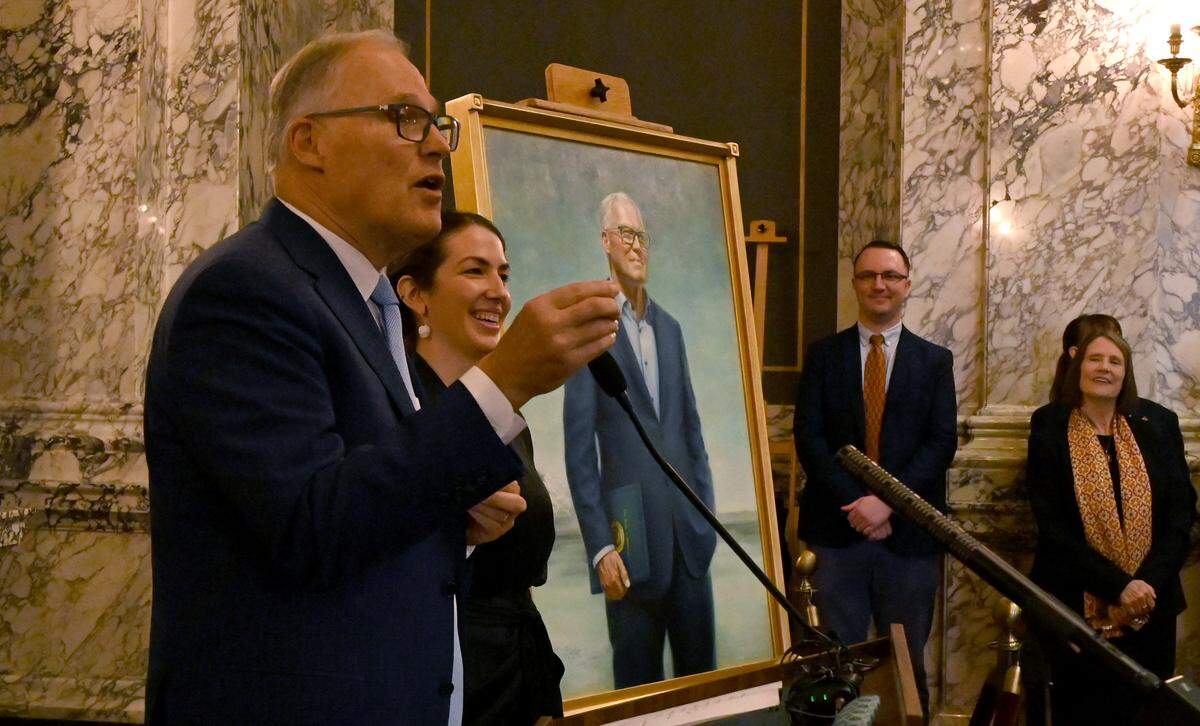 Outgoing Gov. Jay Inslee and artist Grace Athena Flott speak to the audience after an unveiling ceremony for his official portrait in the State Reception Room shortly after he delivered his final State of the State address on Jan. 14, 2025. It was the first time Inslee had seen the portrait created by the Seattle-based artist.