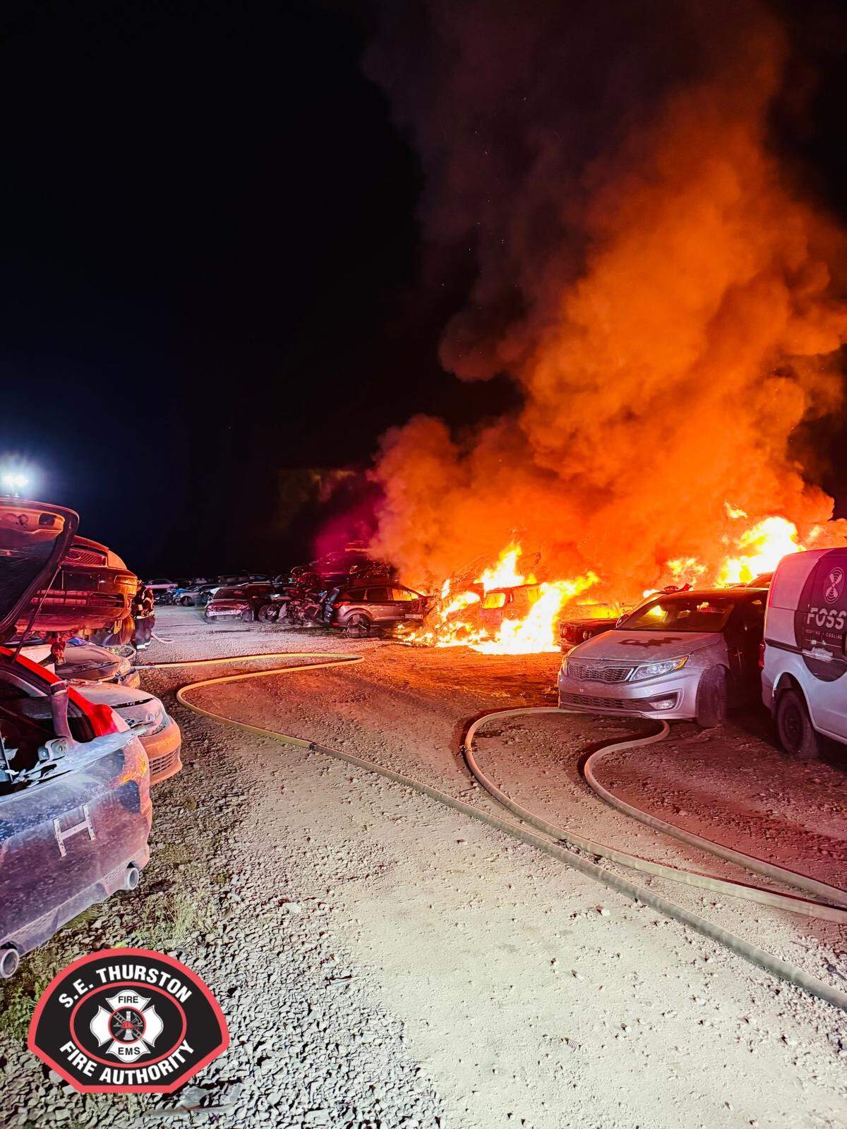 A fire burns many cars at an auto wrecking yard on Northern Pacific Road Southeast in Yelm in the early hours of Thursday, April 30.