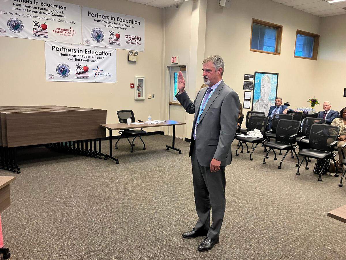 North Thurston Public Schools Superintendent-to-be Troy Oliver participates in a swearing-in ceremony during a board meeting on Tuesday, June 18.