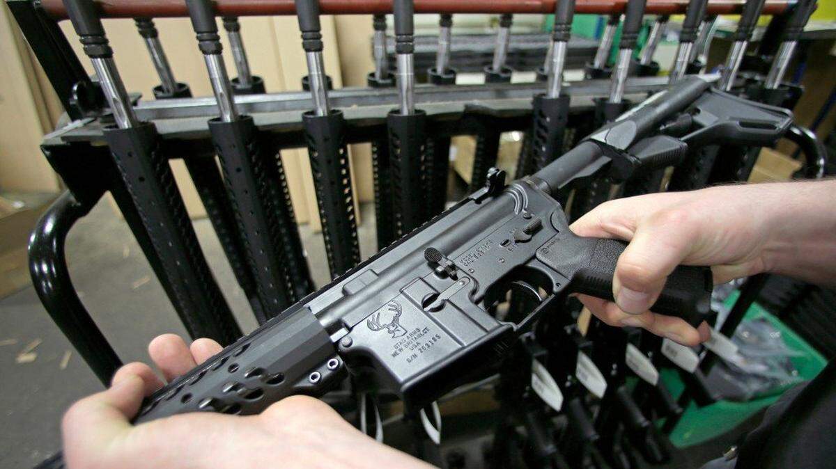 Veetek Witkowski holds a newly assembled AR-15 rifle at the Stag Arms company in New Britain, Conn.