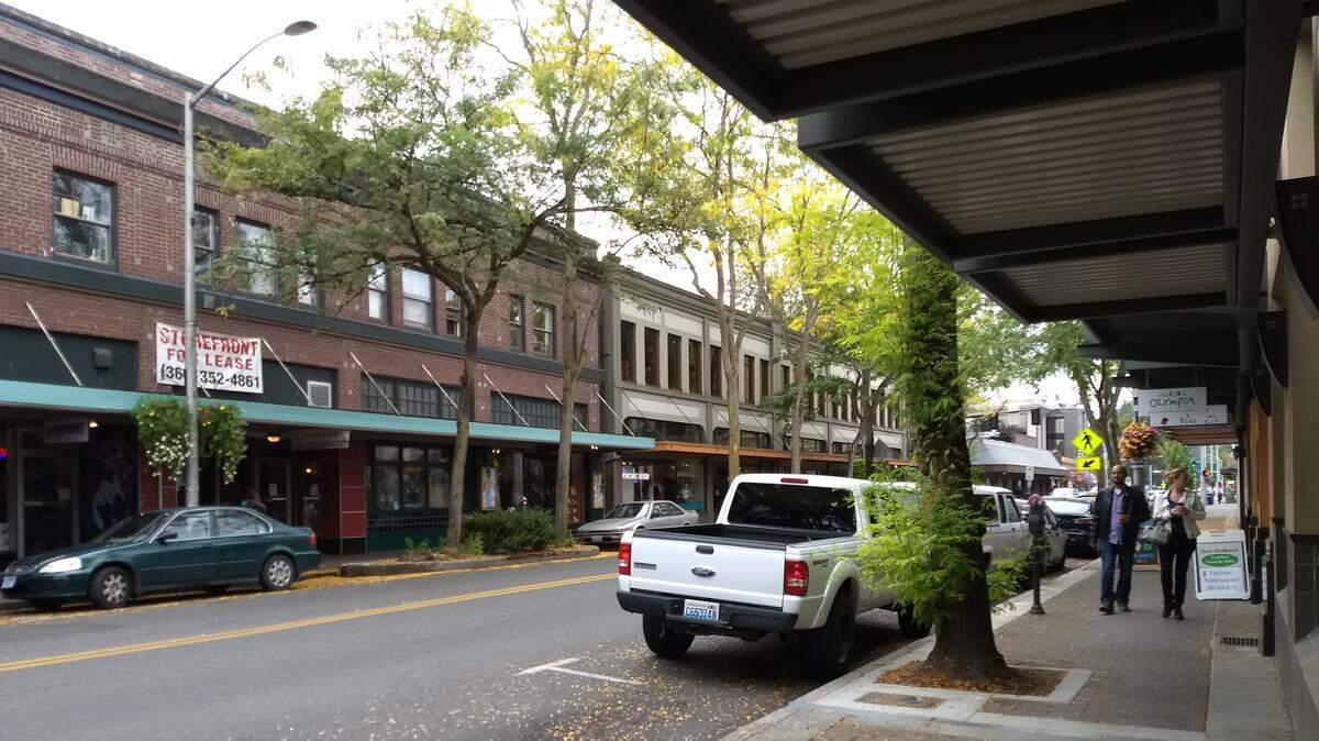 People walk down Fifth Avenue Southeast on Saturday. Since May, downtown businesses and property owners have contracted with Pacific Coast Security for nightly patrols, coordinated by the Olympia Downtown Alliance.