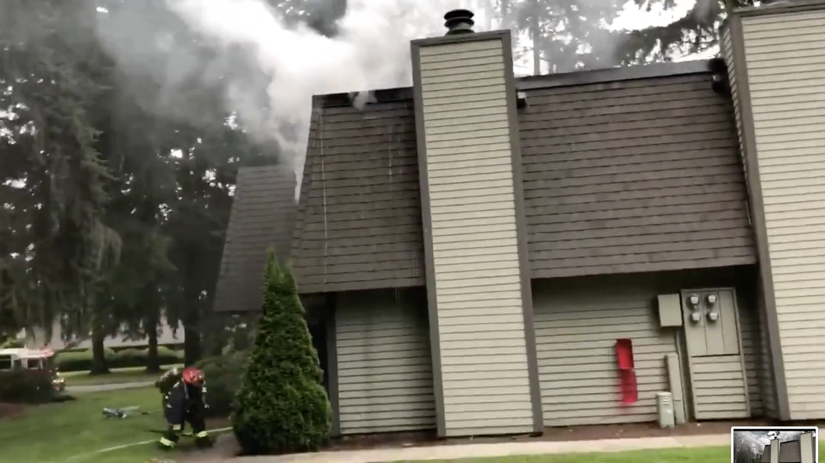 Fire fighters from Lacey and Olympia work to extinguish flames on the second floor of an apartment in the Wilderness West apartment complex.