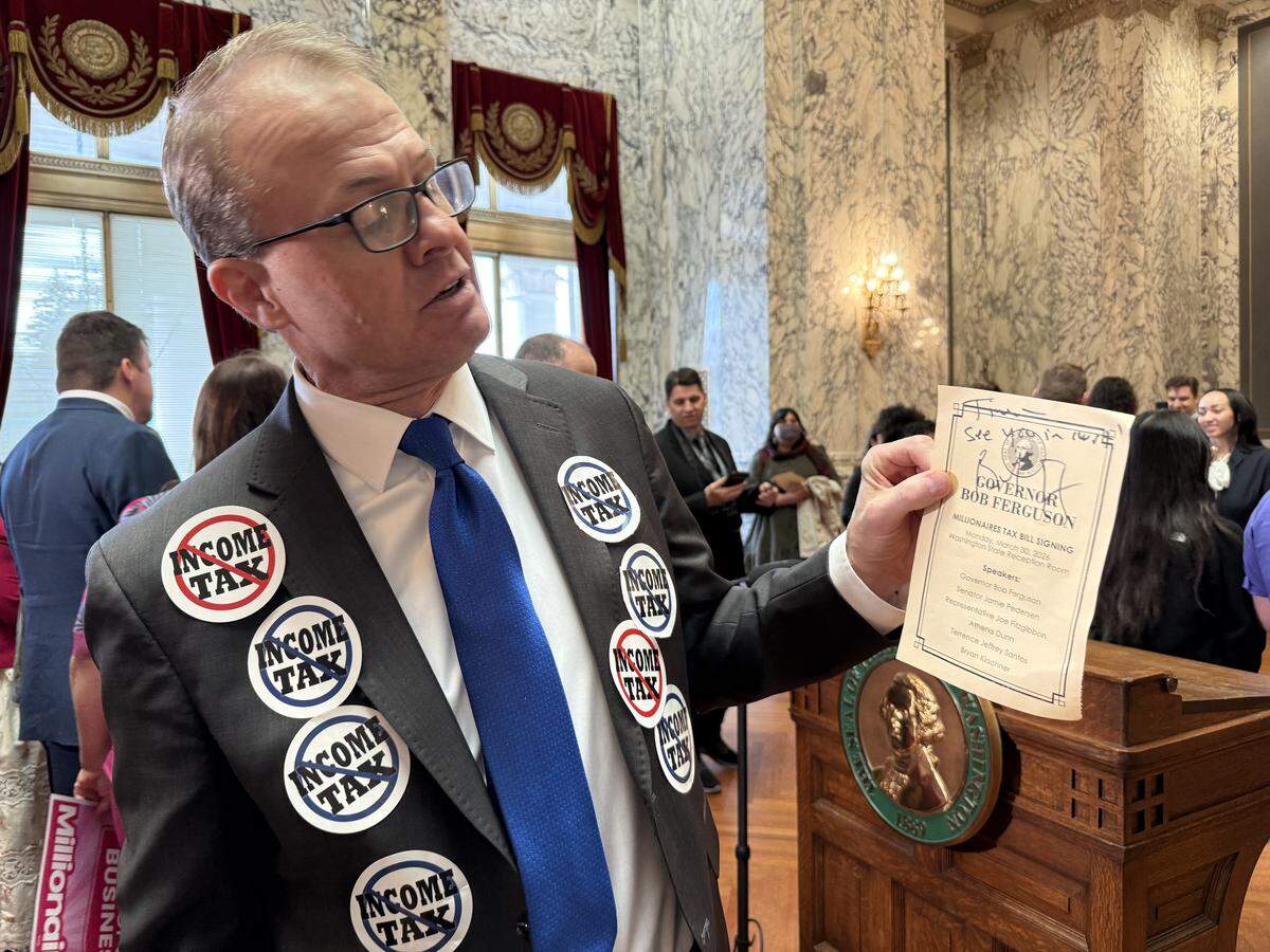 Anti-tax activist Tim Eyman holds up an itinerary signed by the governor on March 30, 2026.