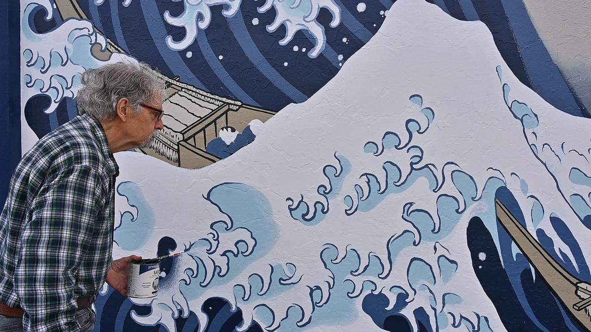 The “Great Wave” mural’s creator, well-known regional artist Joe Tougas, has been observing the project and even added his expertise by handling some of the fine hand drawn detailing near its completion. Here he stopped by quickly on July 31.