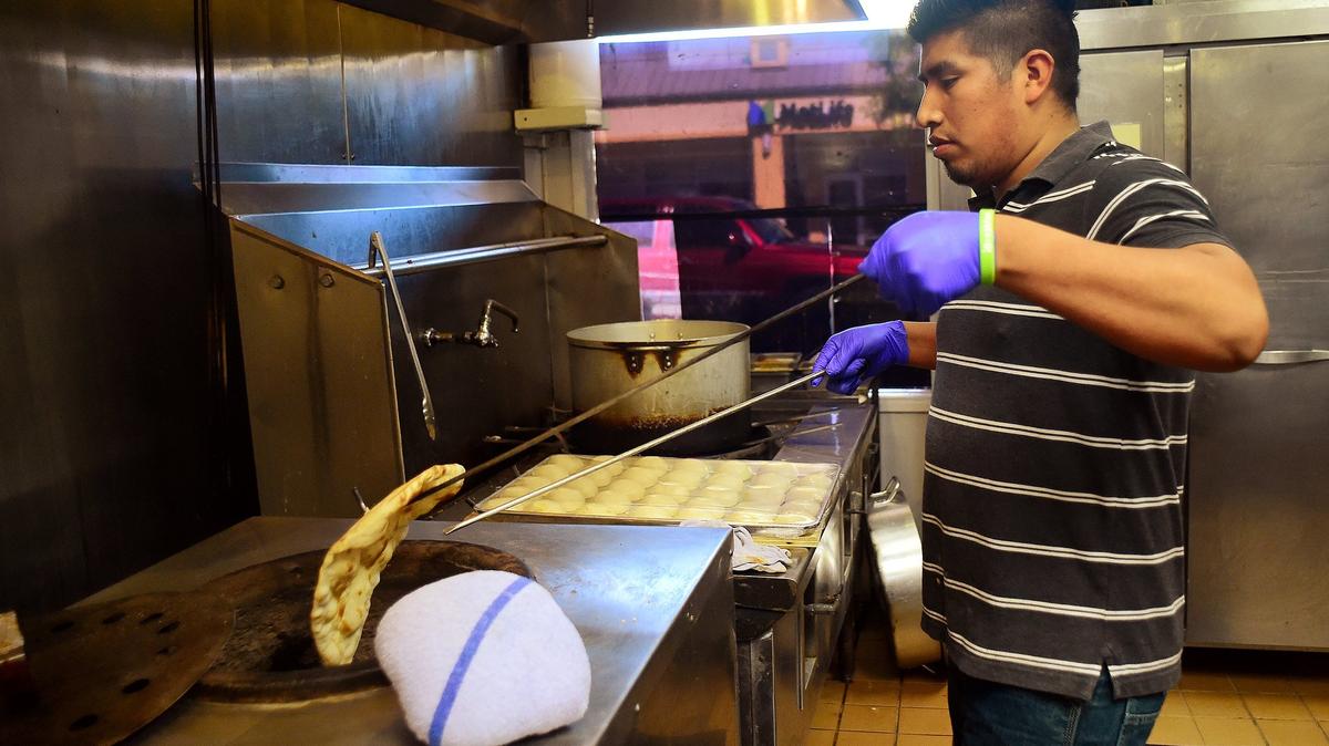 Arturo Cruz prepares traditional naan flat bread in a clay oven at the new Curry King restaurant in Lacey on Aug. 29th.