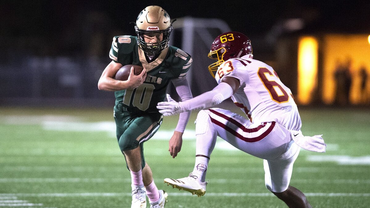 Timberline quarterback Hunter Campau tries to evade Capital defensive back Regan Divina during Friday night’s football game at South Sound Stadium in Lacey on Oct. 12, 2018.