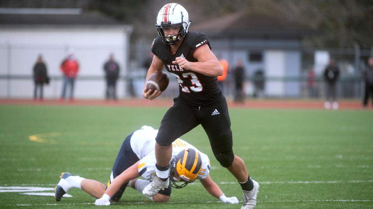 Yelm running back Brayden Platt knocks aside Bellevue defensive end Hogan Hansen as he breaks free in Saturday afternoon’s 3A football state semifinal game at Art Crate Field in Spanaway, Washington, on Nov. 26, 2022. Yelm won the game, 28-27.
