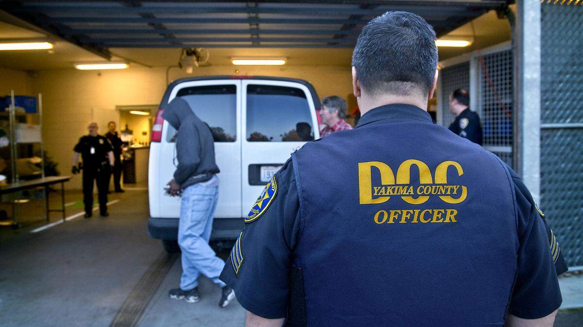 A Yakima County corrections officer guards offenders from Pierce and King counties returning from the Yakima County jail. Olympia is considering contracting with Yakima County to house its inmates.