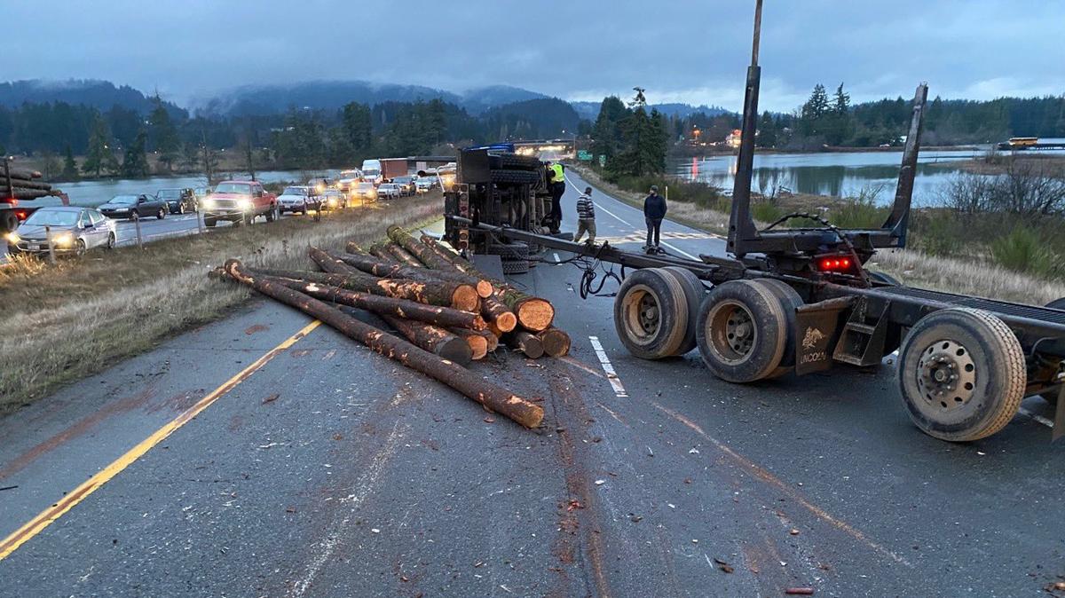A four-vehicle collision on Highway 101 Friday morning in Olympia injured two people and fully blocked the highway after a log truck spilled its load.