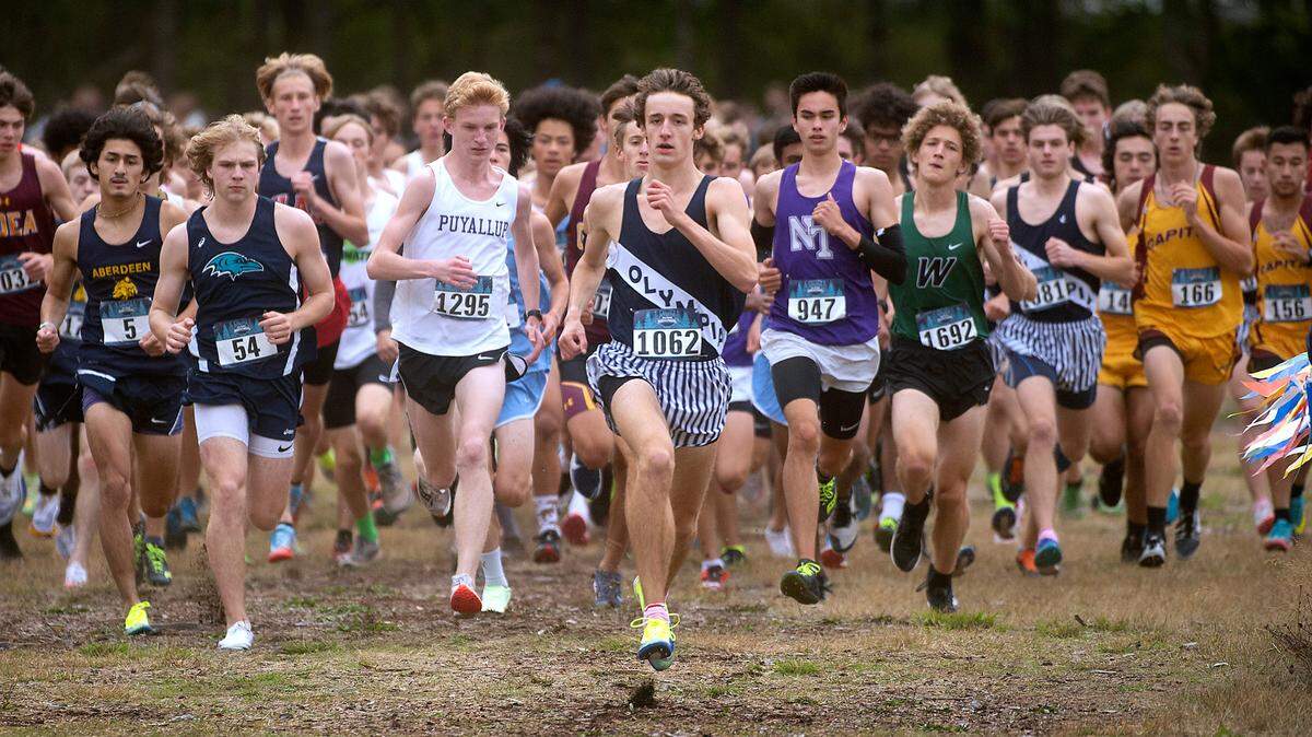 Olympia’s Ethan Coleman (center) leads off the start of the boys elite 5K race during the Bill Kehoe South Sound Invite cross country meet at Saint Martin’s University in Lacey, Washington, on Oct. 9, 2021.