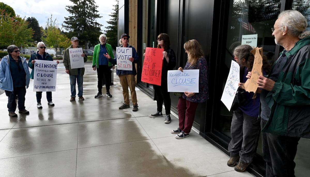 Rallying outside of the Atrium Building in Olympia on Wednesday after a Thurston County Commissioner’s executive session Dave Toller (center) leads a group of supporters for suspended commission member Emily Clouse, and who are asking for answers as to why it is still in force.