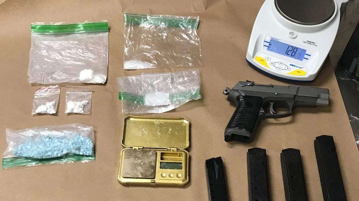 An image of items Olympia police recovered from a Lakewood man accused of robbing two convenience stores and burglarizing a coffee stand on March 11. The image includes a firearm and ammunition, as well as baggies of meth and fentanyl poweder and pills.