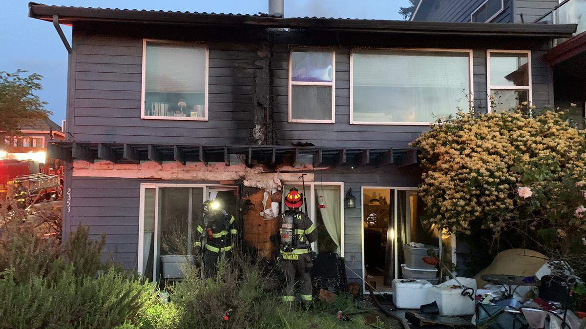 Firefighters assess the damage left by an exterior fire at a home on Crestline Boulevard in northwest Olympia Thursday morning, June 1.