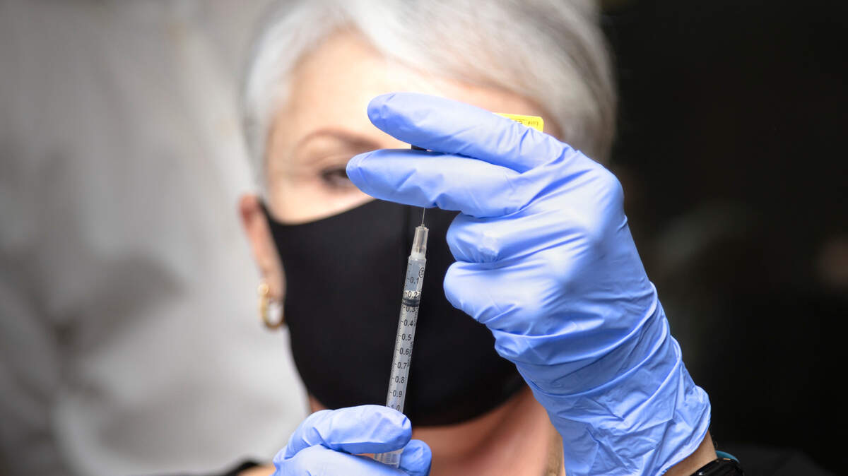 Kernie Moeller, nurse from the Thurston County Medical Reserve Corp, draws the first COVID-19 vaccination Friday, Dec. 18 as vaccinators from Providence Health and Services Southwest Washington began administering the vaccine.
