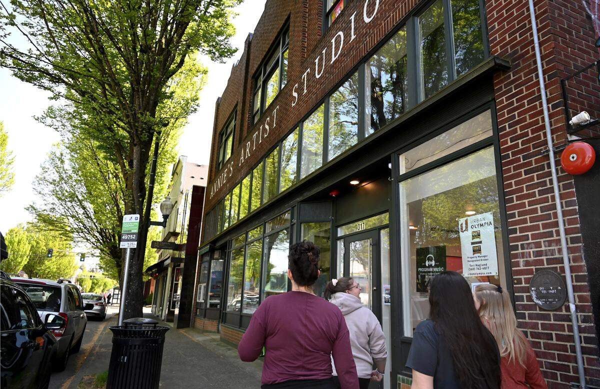 Pedestrians walk down Fourth Avenue East between Franklin and Adams streets in downtown Olympia.