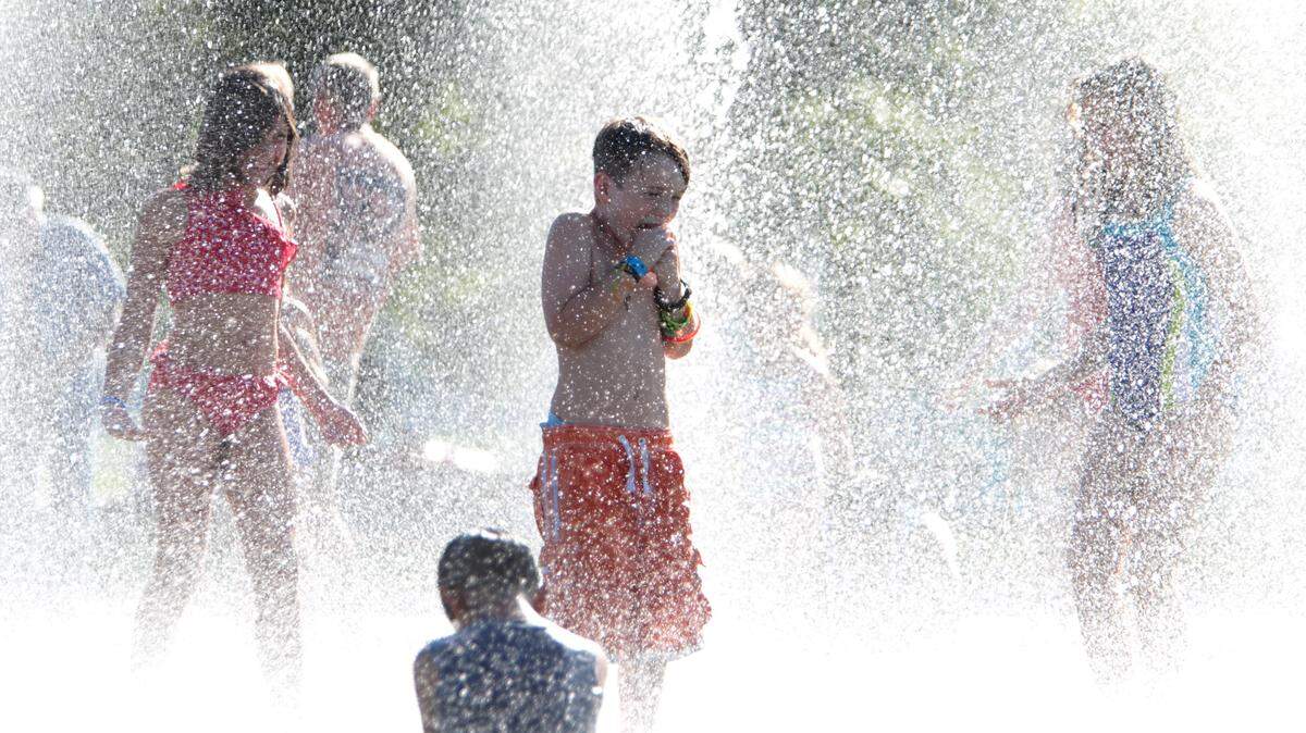 Kids take refuge from the heat at the Heritage Park Fountain in downtown Olympia.