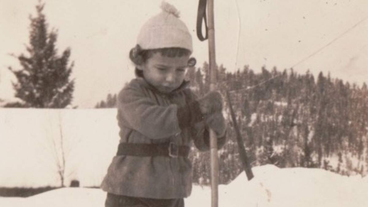 Dorothy Wilhelm at her Montana home at Christmastime. Her home’s roofline is that black line behind her. The snow really did come up to the roof.