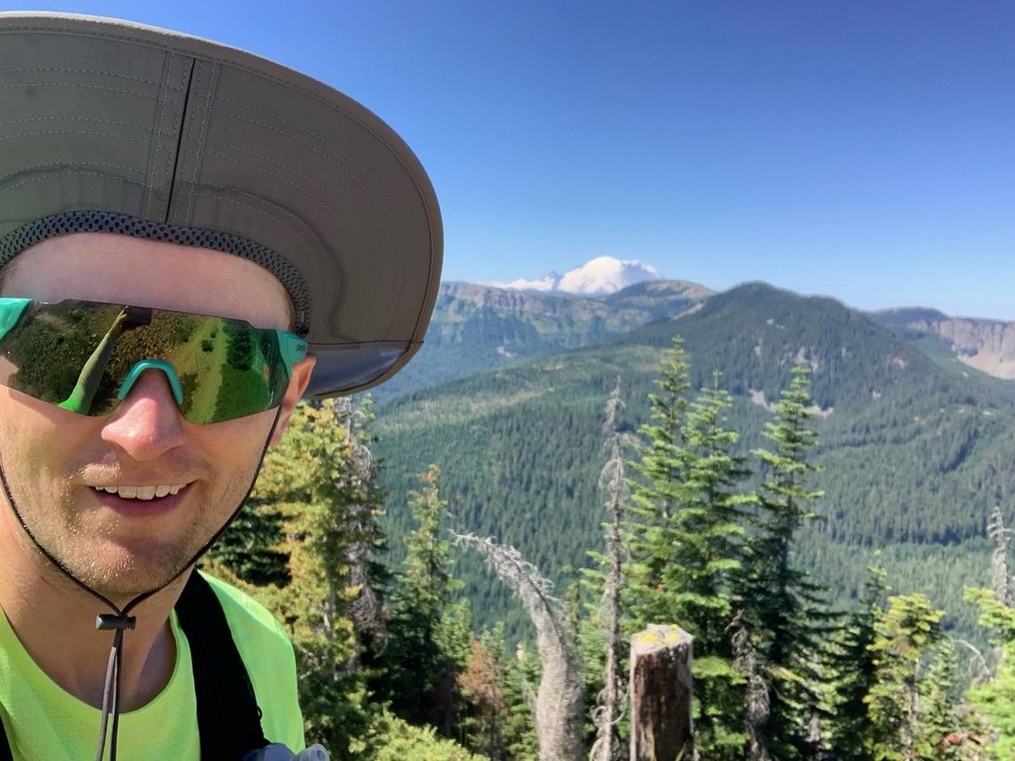 Shaun Haby posing at a view of Mount Rainier on the course.
