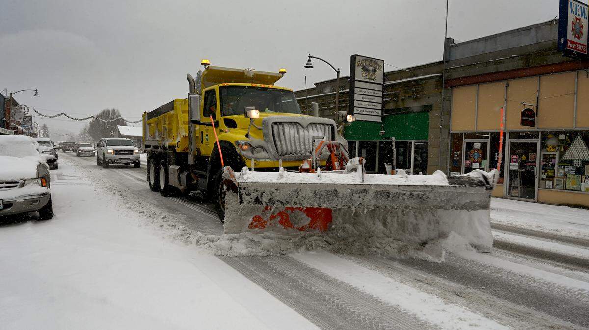 A Washington Department of Transportation truck leads the way along Sussex Avenue East in Tenino early Sunday while working to clear several inches of snow that fell overnight in South Sound.
