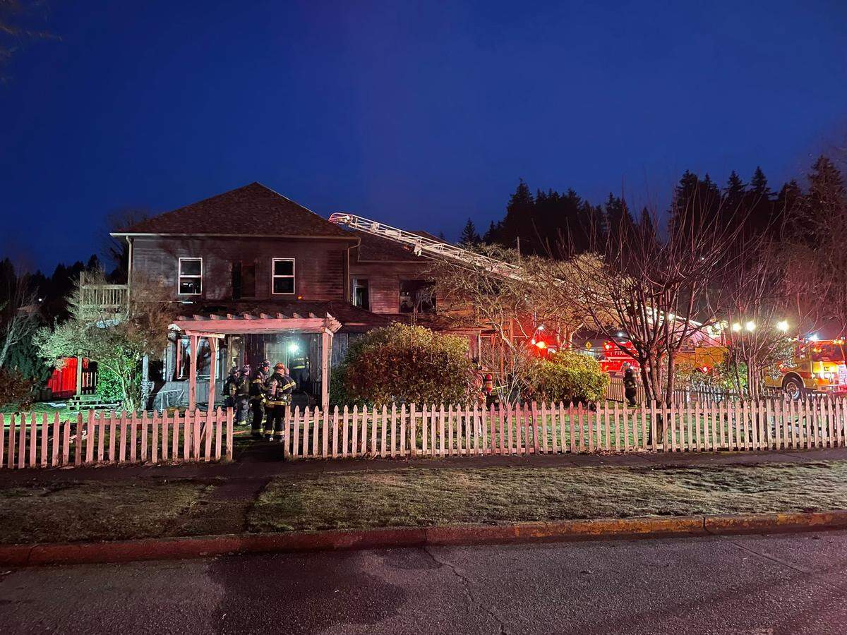Firefighters from Central Mason Fire and EMS stand outside a home on the corner of North First Street and West Pine Street in downtown Shelton in early hours of Wednesday, Feb. 15, 2023.