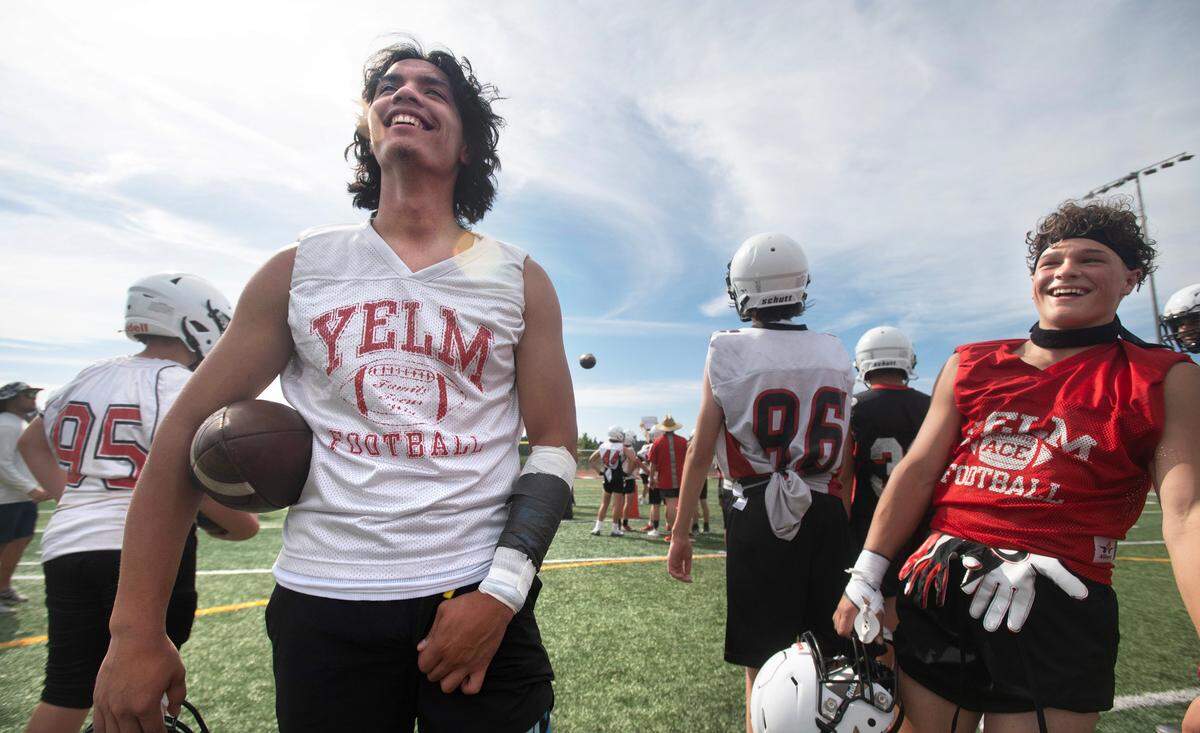 Yelm quarterback Damian Aalona (left) and wide receiver Davin Kirkwood laugh between drills during the Tornados’ preseason football practice at Yelm High School in Yelm, Washington, on Thursday, Aug. 17, 2023.
