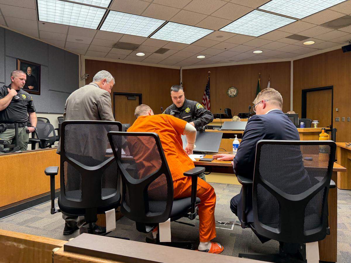 Nicholas Denham, 37, gets fingerprinted in Thurston County Superior Court on Dec. 18, 2025. Judge Carol Murphy sentenced Denham to life in prison for killing a 34-year-old mother and her 4-year-old daughter in March 2020. This is the second time Denham has been convicted and sentenced.