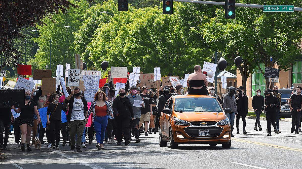 Rally organizer Jazmyn Pereira uses a bull horn to encourage several hundred protesters who gathered in the parking at the Capital Mall in west Olympia June 1 to protest the May 25 death of George Floyd in Minneapolis while in police custody. After a short rally with several speakers, the group marched along the mall’s’ perimeter, then along Cooper Point Road and Harrison Avenue before returning to the mall parking lot.