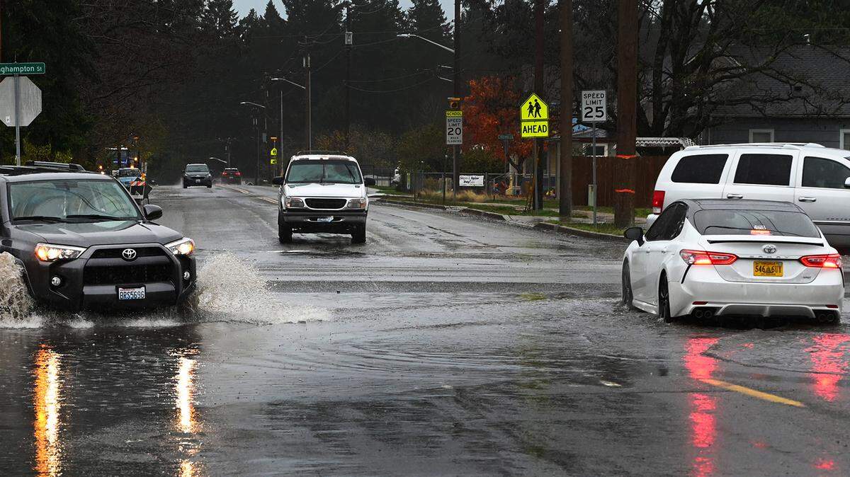 Motorists negotiate standing water at the intersection of Binghampton St. and Centre St. N in Rainier on Friday around noon as torrential rains hit the region, causing several area flood warning in their wake.