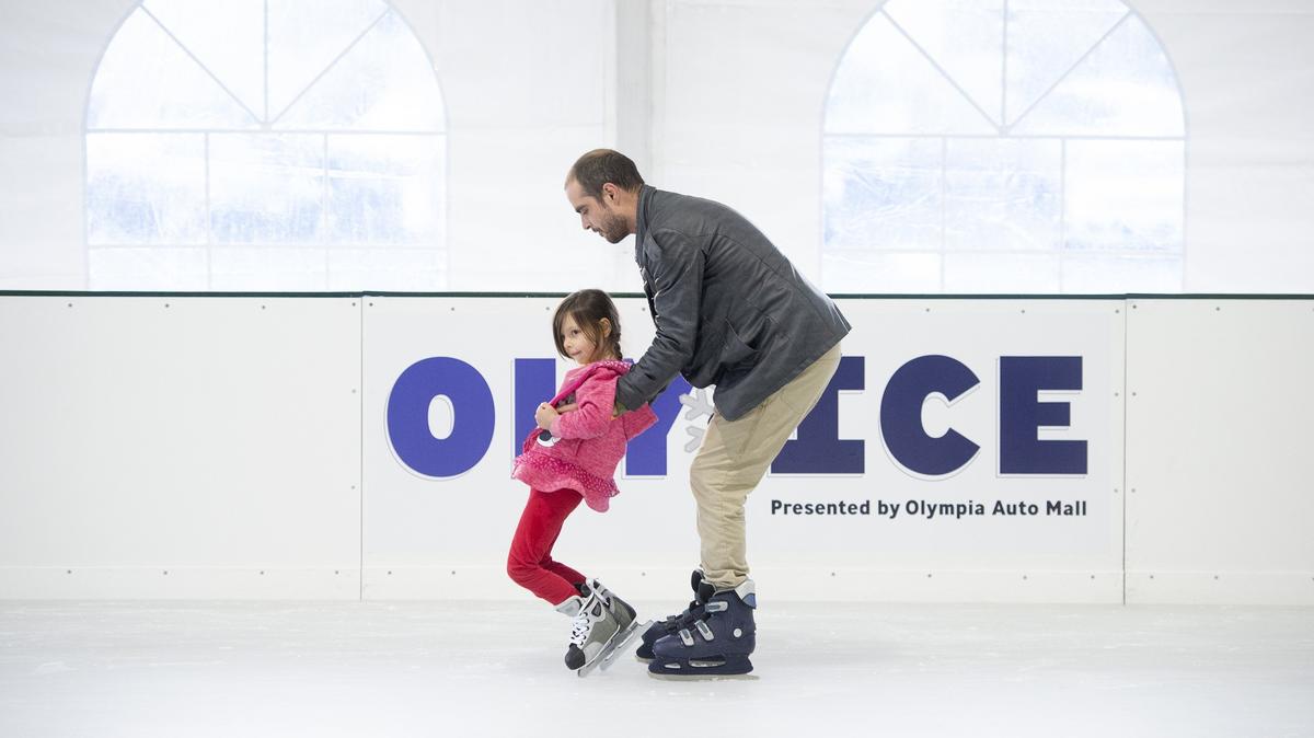 Michael Looney of westside Olympia helps his daughter, Cara Looney, 5, as they hit the ice for the opening day at the “Oly on Ice” skating rink on the isthmus on the downtown Olympia waterfront on Friday, Nov. 16, 2018.