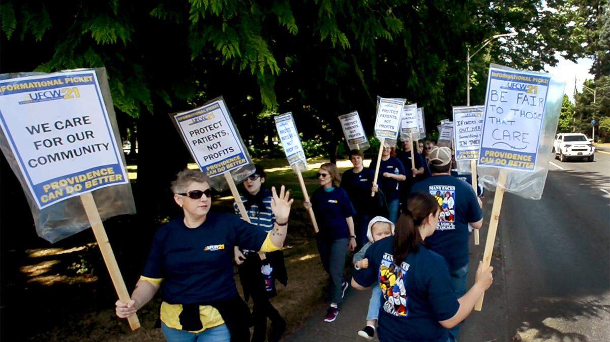 Nurses, hospital staff and supporters picket in front of Providence St. Peter Hospital in Olympia in 2019.