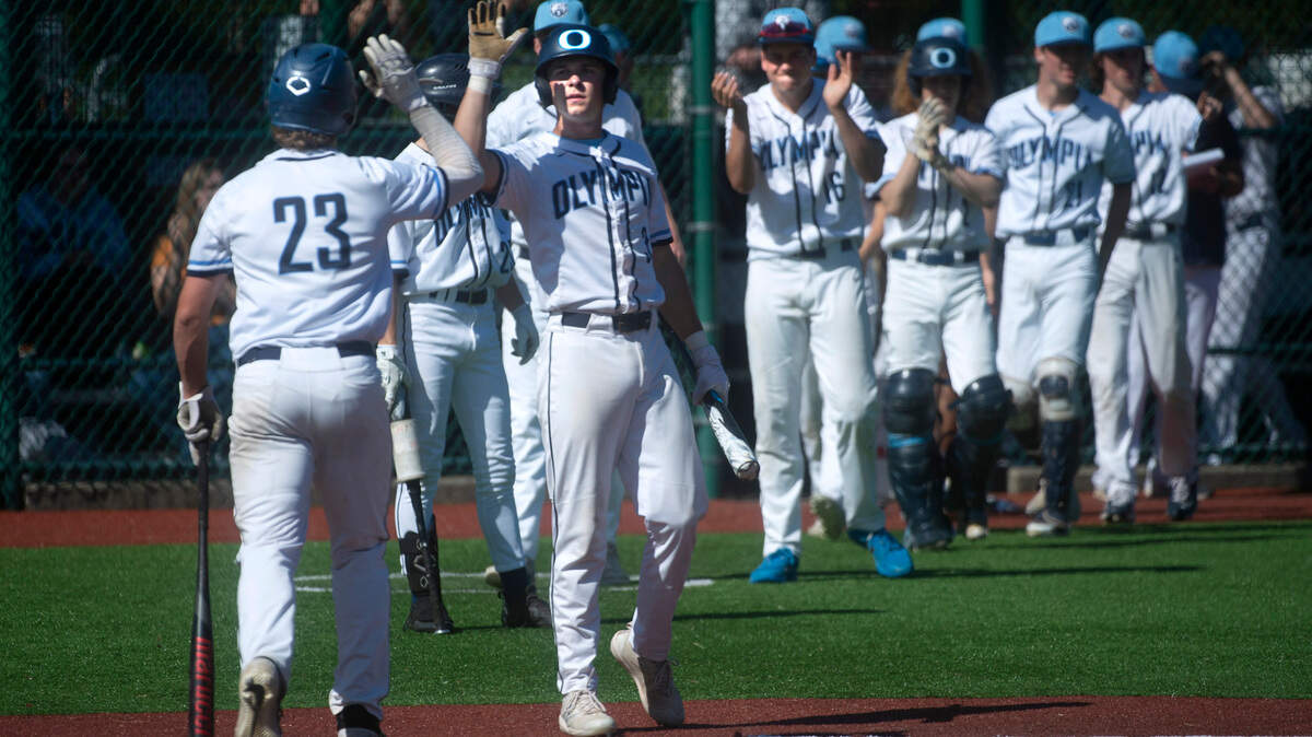 Olympia’s Logan Shepherd (23) is congratulated by teammate Brody Phinney after scoring during the Bears 6-0 victory over Issaquah in the quarterfinal round of the 4A state baseball tournament at the Regional Athletic Complex in Lacey, Washington, on Saturday, May 22, 2022.
