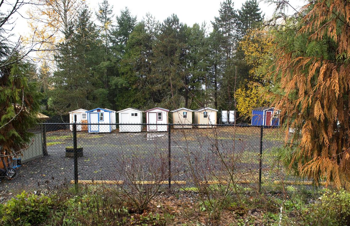 Tiny houses wait to be positioned Friday at Olympia’s newest tiny home village for homeless people, set to open in January.