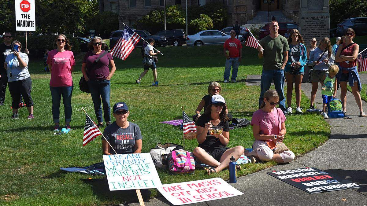 Attendees at Tuesday’s Strike 4 Schools rally at Sylvester Park in Olympia, across from the Office of Superintendent of Public Instruction, display signs opposing mandatory masks and vaccinations in schools.