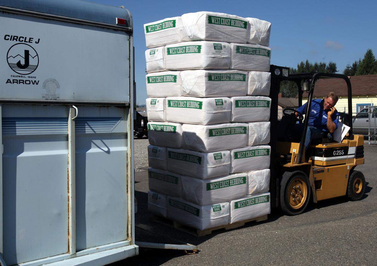 File photo: Craig Kinnaman fills the back of a waiting horse trailer with bedding material as warm weather and hotter special prices kept a steady line of over several hundred customers filing in for Kiperts Korner Feed's anniversary sale.