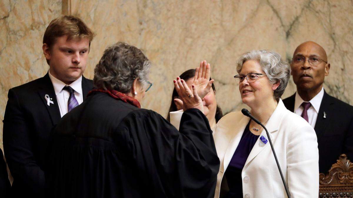 House Speaker Laurie Jinkins, D-Tacoma, second from right, is sworn in by former Washington Supreme Court Chief Justice Mary Fairhurst, second from left, Monday on the first day of the 2020 session of the Washington Legislature at the Capitol in Olympia.