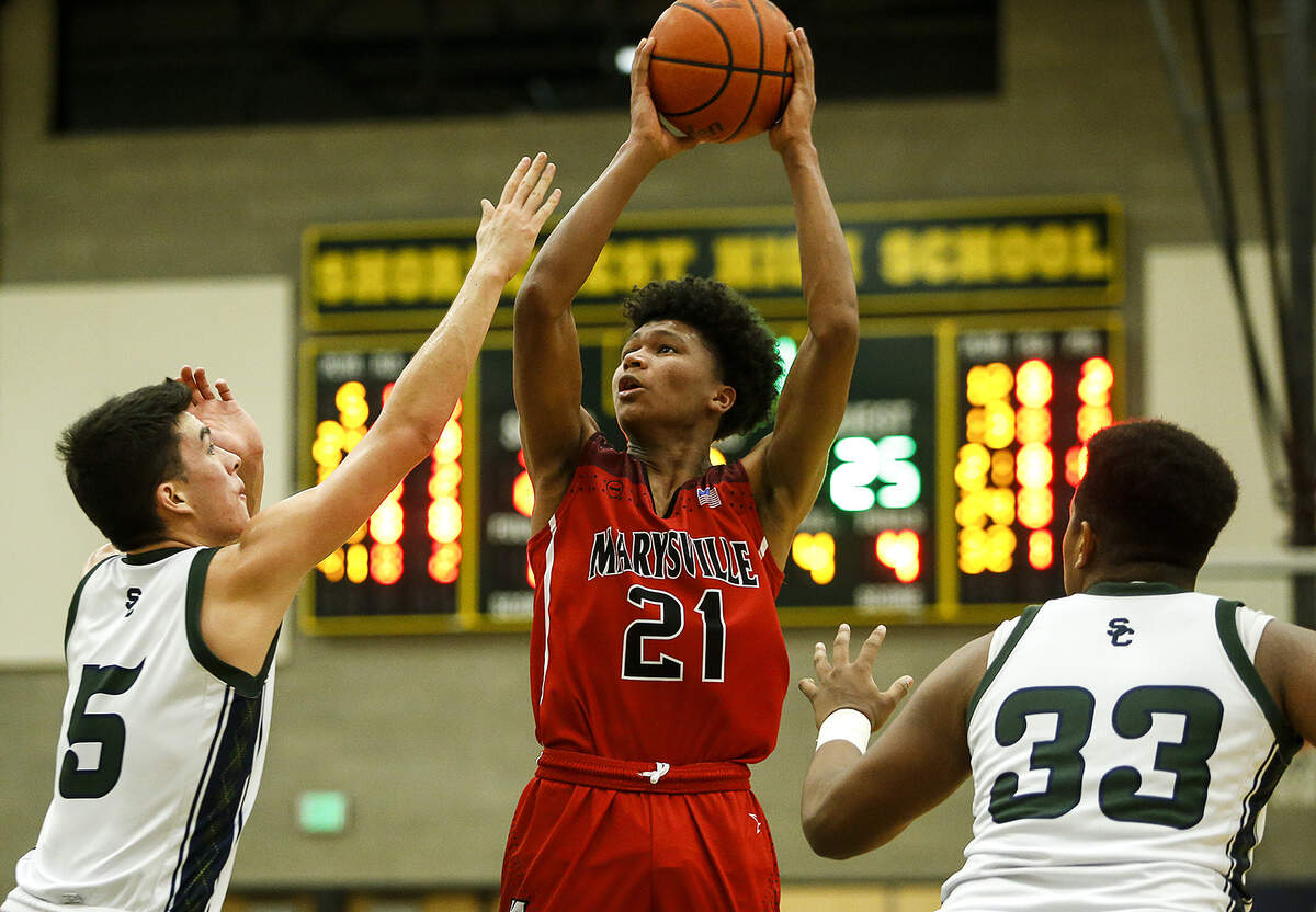 Marysville Pilchuck’s Raequan Battle (center) takes a shot as Shorecrest’s Chris Lee (left) and Eladio Fountain (right) defend during a game at Shorecrest High School in Shoreline on Tuesday, Jan. 9, 2018.