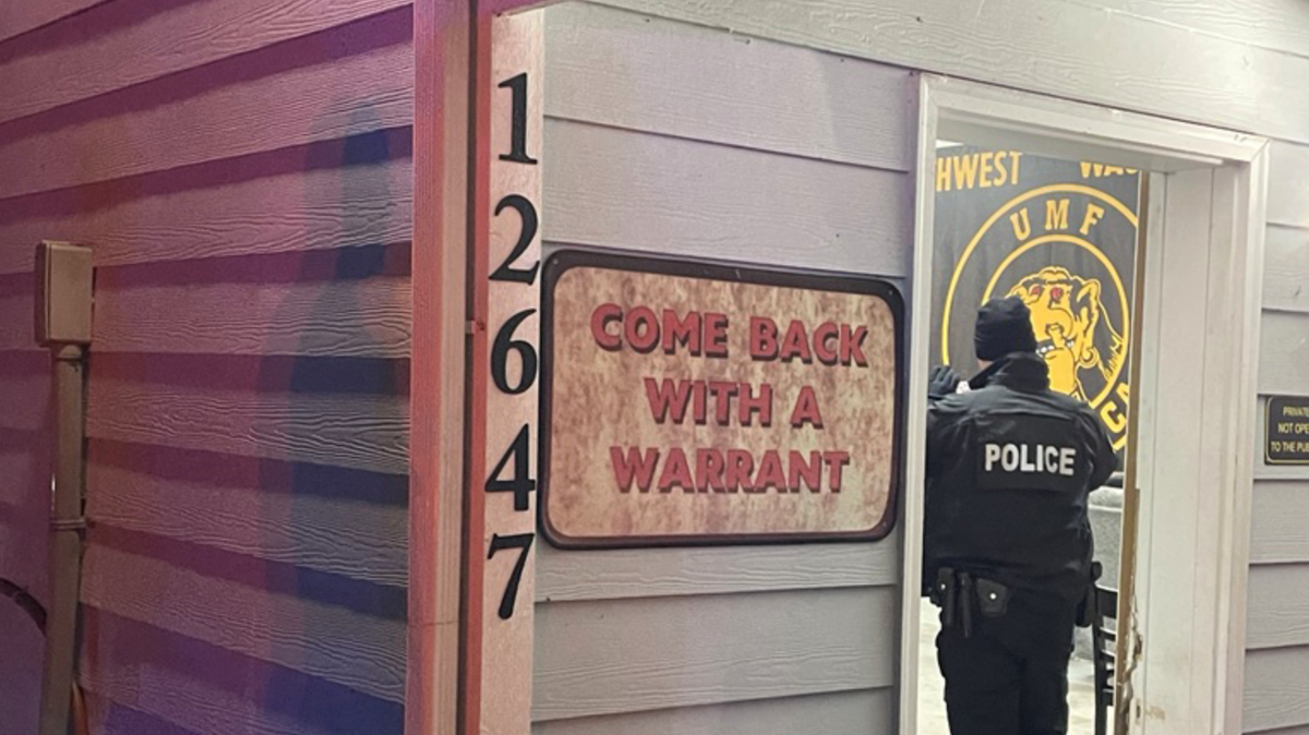 An officer enters a clubhouse for the Northwest Chapter of UMF of America at 12647 Littlerock Road SW in south Thurston County. Washington’s Liquor and Cannabis Board alleges the clubhouse operated an unlicensed bar.